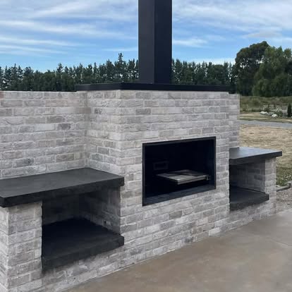 Built-in brick outdoor fireplace with side benches