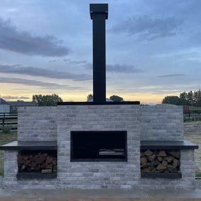 Built-in outdoor fireplace with wood storage on both sides